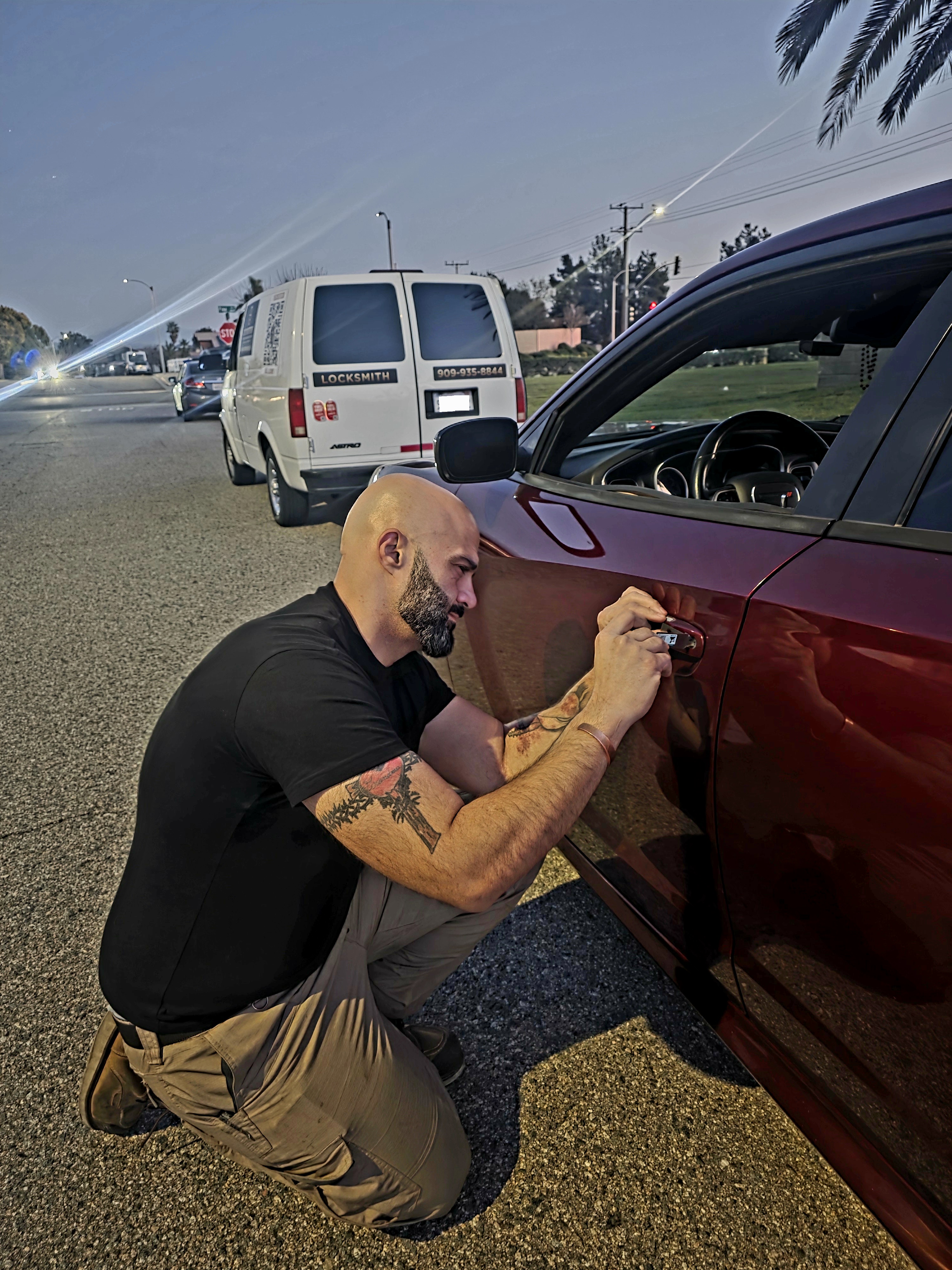 Lock Busters technician in San Bernardino picking a car door to decode and cut a new key fob key.